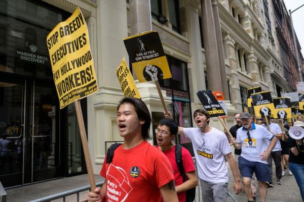 Screen Actors Guild-American Federation of Television and Radio Artists members walk a picket line outside of Warner Bros. Discovery on Aug. 10, 2023, in New York City. 