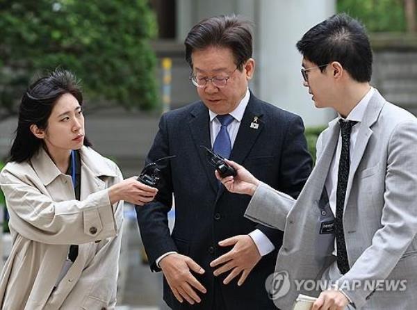 Democratic Party Chairman Lee Jae-myung (C) is approached by reporters at the Seoul Central District Court on April 16, 2024. (Yonhap)