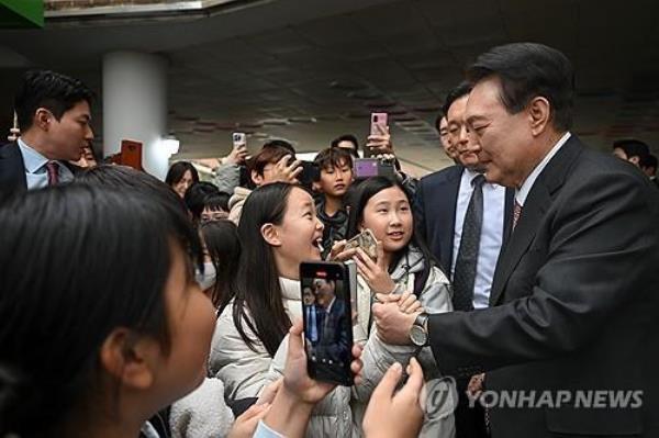 President Yoon Suk Yeol communicates with students after taking part in an after-school program for first graders at Ain Elementary School in Hwaseong, 45 kilometers south of Seoul, on March 29, 2024, in this photo unrelated to this article provided by his office. (PHOTO NOT FOR SALE) (Yonhap)