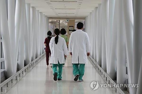 Doctors walk down a hallway at a hospital in Seoul on March 24, 2024. (Yonhap) 