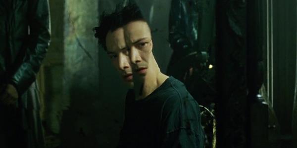Neo looks at a mirror in The Matrix