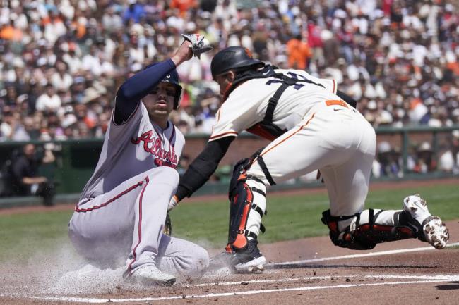 The Atlanta Braves’ Austin Riley, left, scores against Giants catcher Patrick Bailey during the first inning Saturday in San Francisco. (Jeff Chiu / ASSOCIATED PRESS)