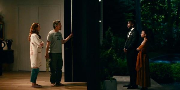 The Scotts standing in front of the Sandfords, with the door open in Leave the World Behind. 